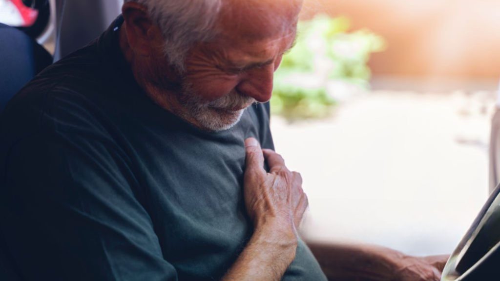 Older man holding chest showing heart strain from poor sleep