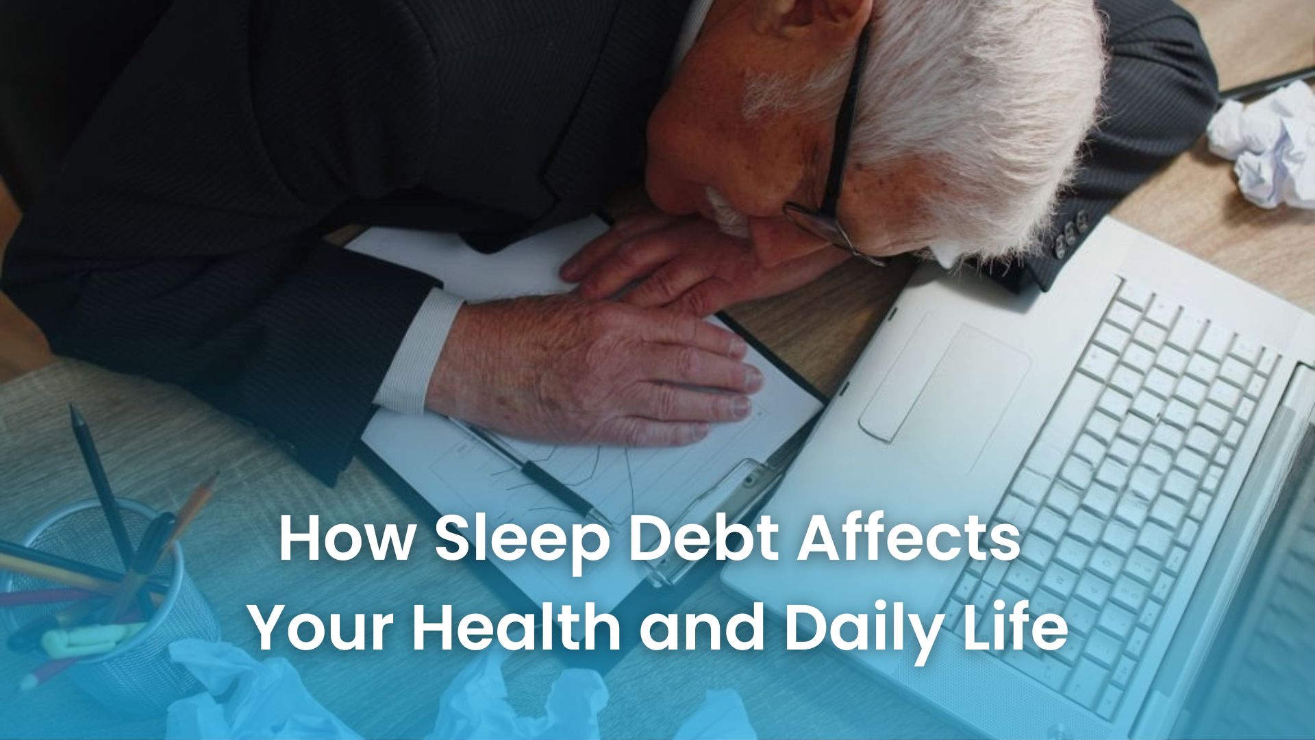 Office worker asleep at desk showing effects of sleep debt